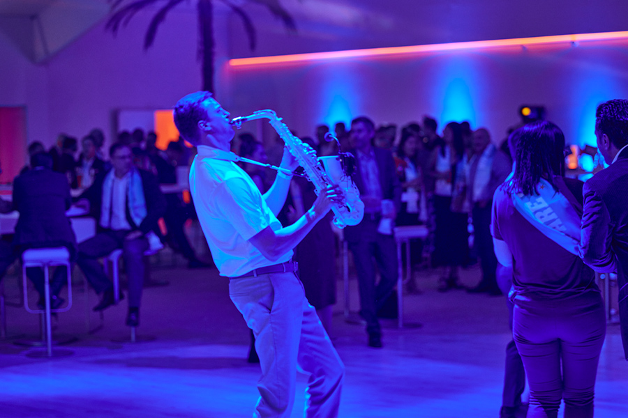 Saxophonist Marius Trapp auf der Tanzfläche eines Firmenevents in blauem Licht