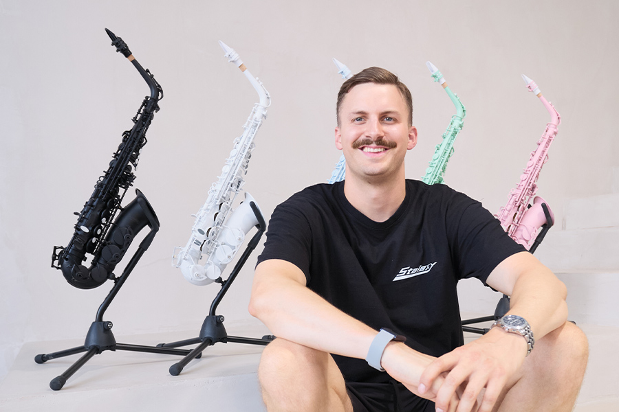 Marius Trapp sitzt vor mehreren farbigen Stalaxy Saxophonen